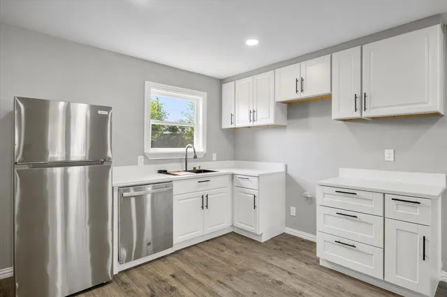a kitchen with white cabinets and white appliances