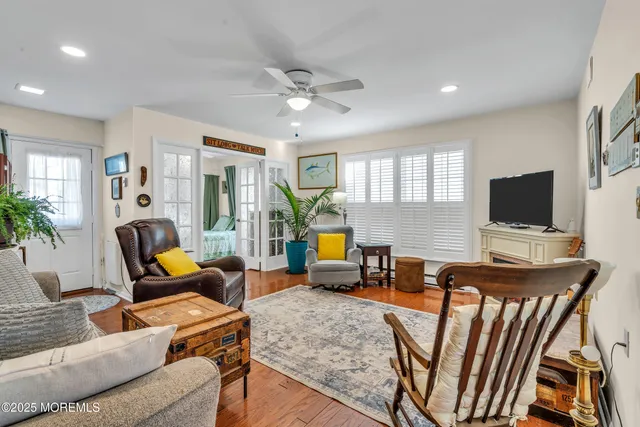 a living room with furniture a flat screen tv and a large window