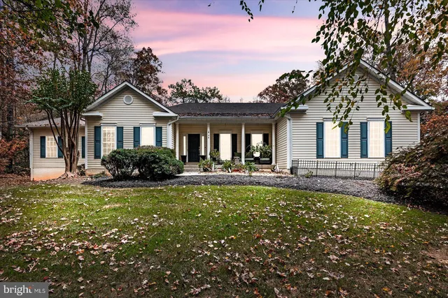 a front view of a house with a garden and trees
