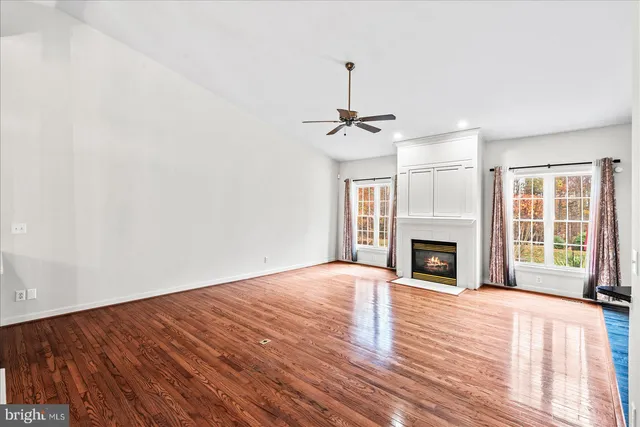 a view of empty room with wooden floor and fireplace