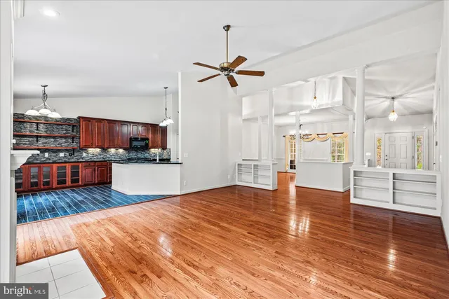 a kitchen with white cabinets and wooden floor