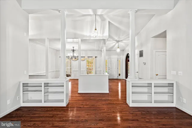 a view of an empty room with wooden floor fireplace and a window