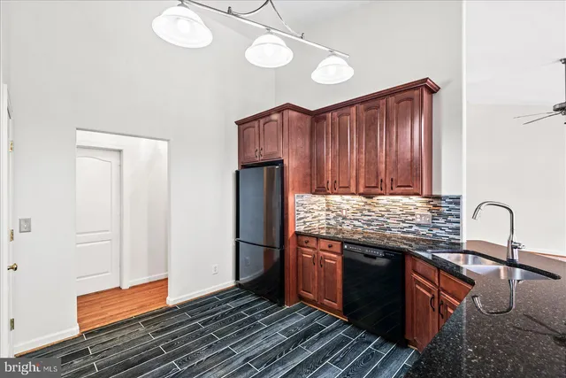 a kitchen with granite countertop stainless steel appliances and wooden cabinets