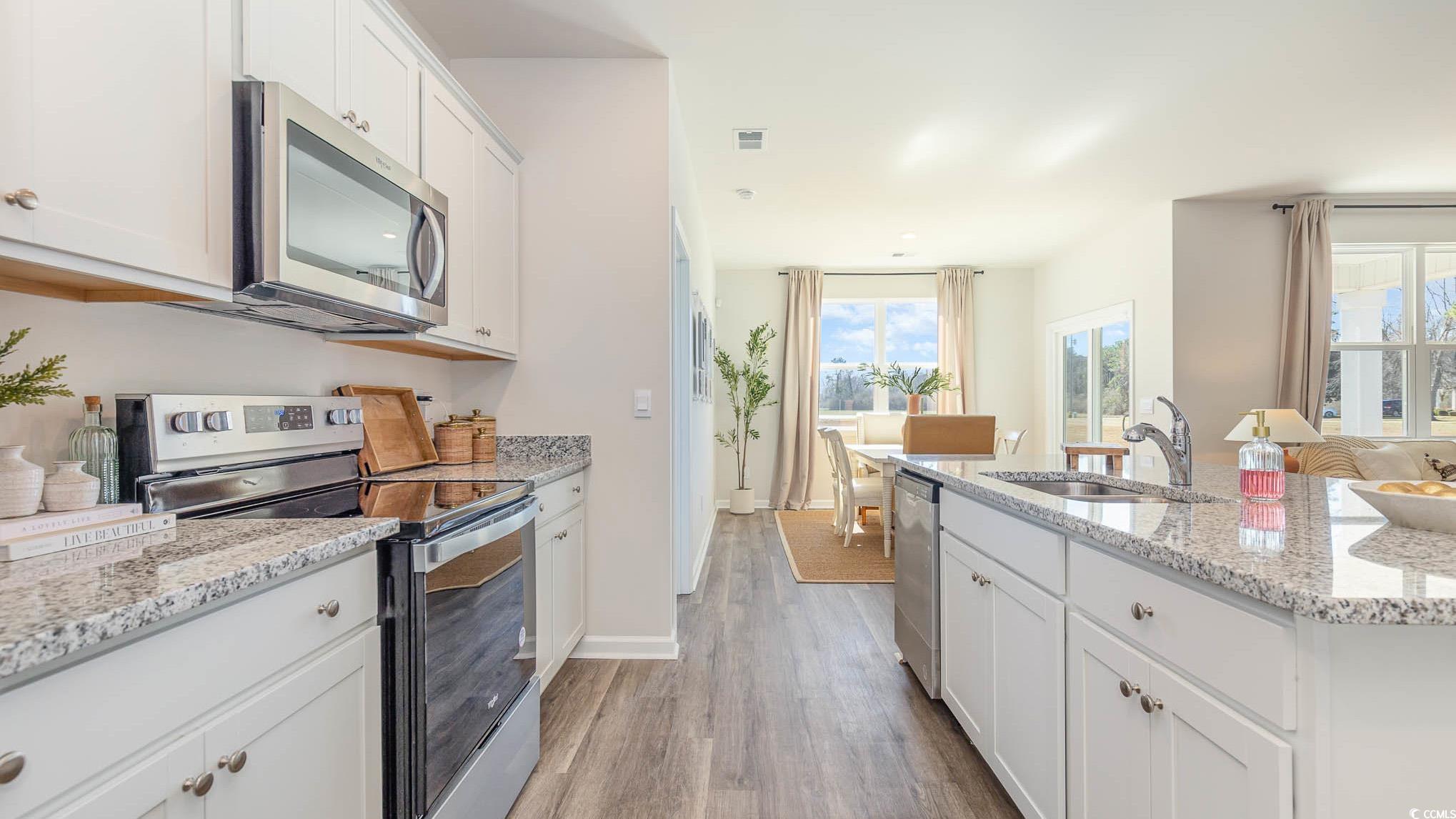 1013 St Martin Street Georgetown, SC 29440 - Photo 5 of 24 Kitchen with stainless steel appliances, white cabinetry, and light wood-style floors