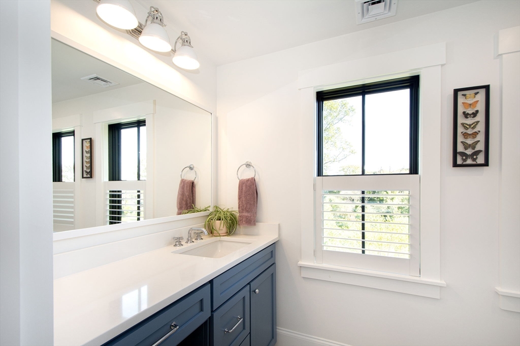 453 Clapp Road Scituate, MA 02066 - Photo 13 of 17 a bathroom with a granite countertop sink a large mirror and a window