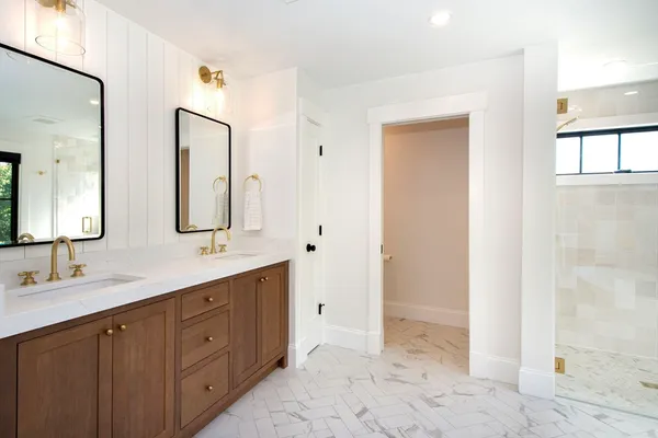a spacious bathroom with a double vanity sink a mirror and a
