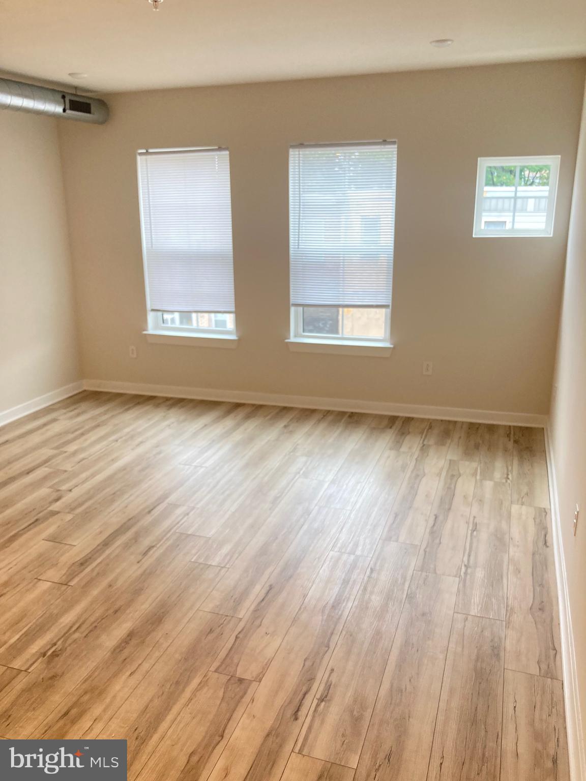 2551 North Front Street, Unit 3 Philadelphia, PA 19133 - Photo 5 of 16 a view of an empty room with wooden floor and a window