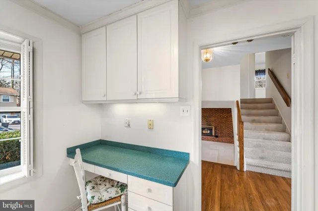 a kitchen with white cabinets and a wooden floor