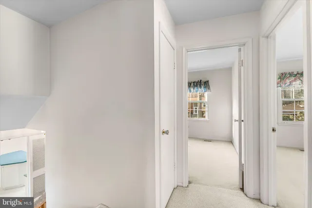 a view of a hallway with wooden floor and a living room