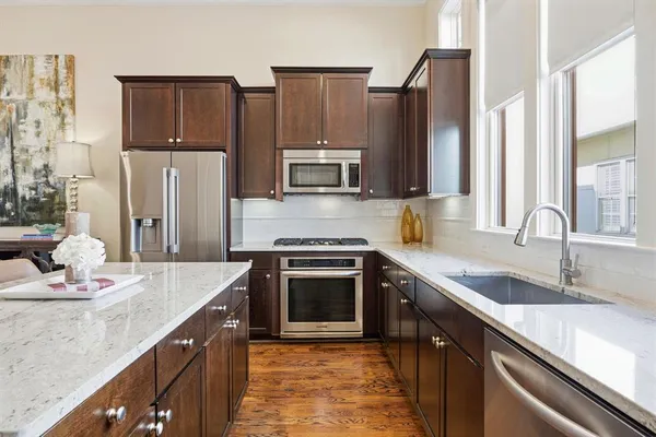 a large kitchen with granite countertop a sink and cabinets