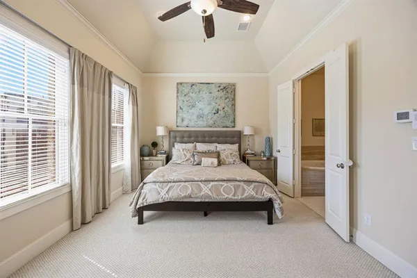 a spacious bedroom with a bed and a chandelier