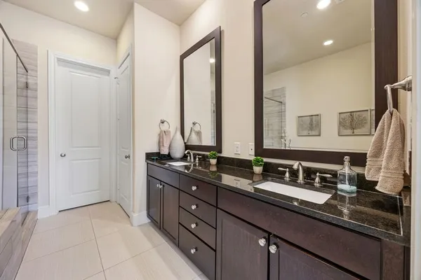 a bathroom with a granite countertop tub sink and mirror