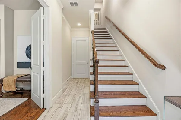 a view of a hallway with wooden floor and entryway
