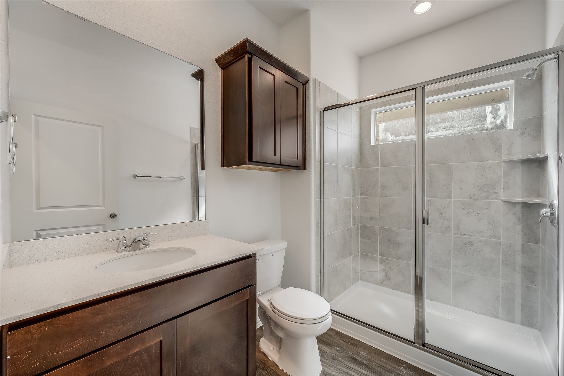 932 Mallow Road Leander, TX 78641 - Photo 29 of 40 Full bathroom featuring a dark wood-finish vanity with an integrated sink, a quartz-look countertop, and a large frameless mirror