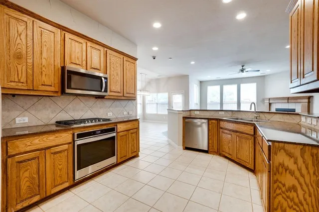 a kitchen with stainless steel appliances granite countertop a stove a sink and a microwave