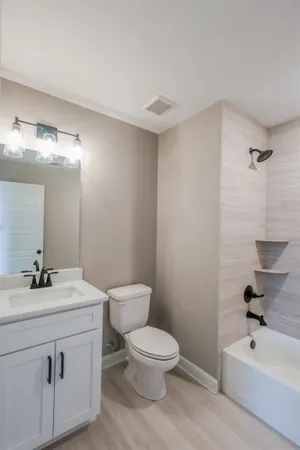 a bathroom with a granite countertop sink toilet and mirror