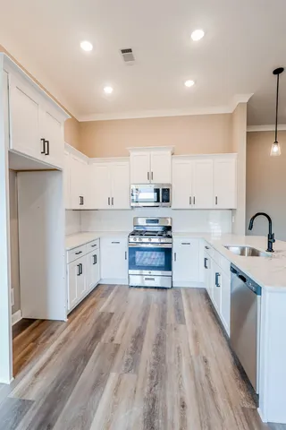 a kitchen with a sink stainless steel appliances and cabinets