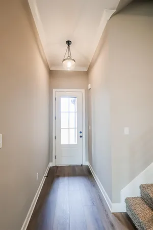 a view of an empty room with wooden floor fireplace and a window
