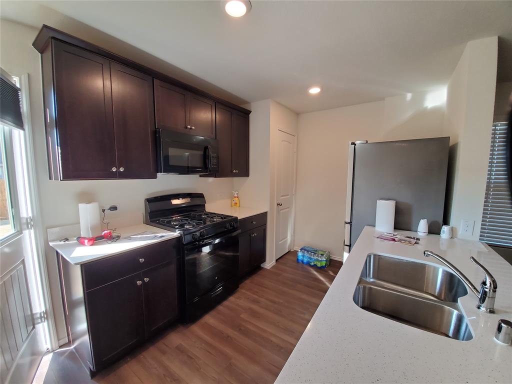 414 Sweetshade Lane Princeton, TX 75407 - Photo 2 of 10 a kitchen with a sink stove and cabinets