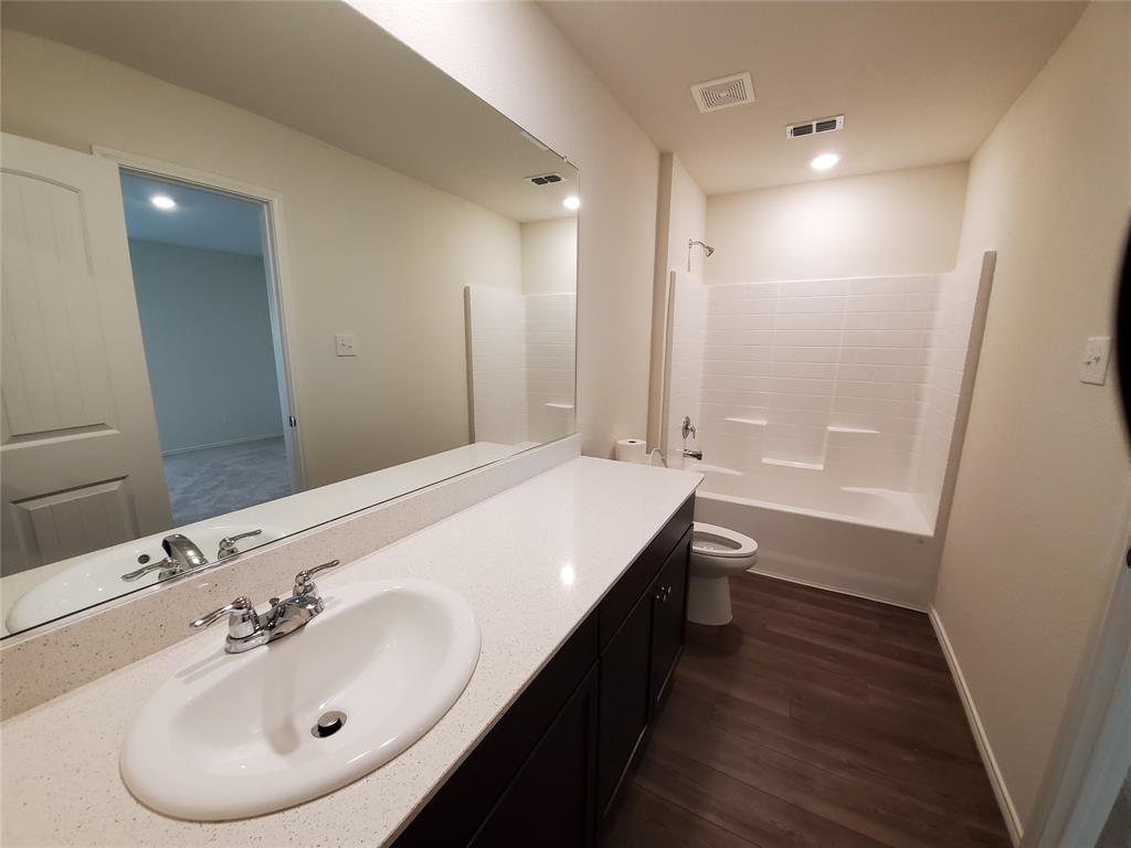 414 Sweetshade Lane Princeton, TX 75407 - Photo 5 of 10 a bathroom with a sink a toilet and shower