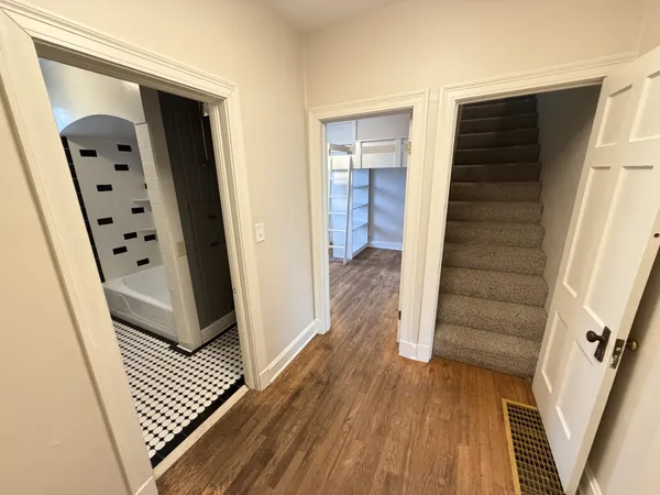 a view of a hallway with wooden floor and staircase