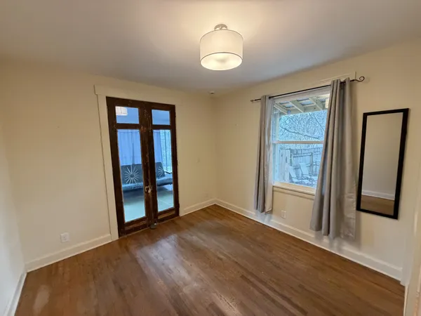 a view of empty room with wooden floor and window