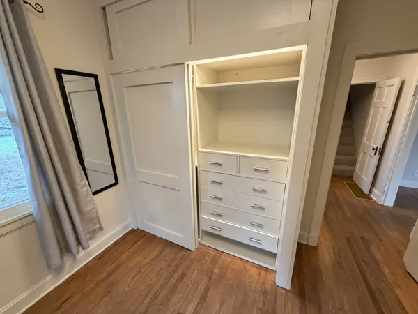 a view of walk in closet with wooden floor