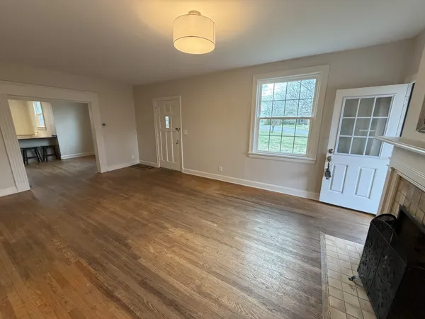 a view of empty room with wooden floor