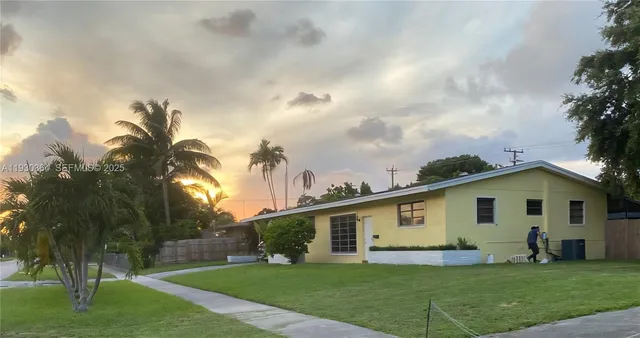 a view of a house with a big yard and potted plants