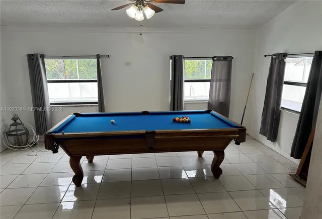 a room with furniture pool table and windows