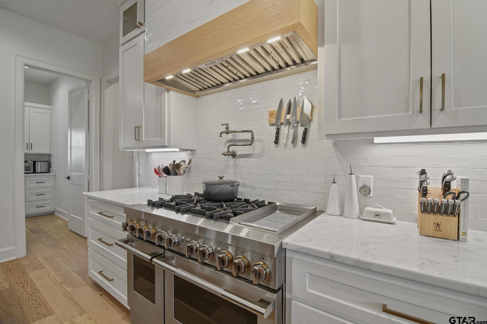 1242 Colt Lane Tyler, TX 75703 - Photo 12 of 47 a kitchen with a stove and a white cabinets