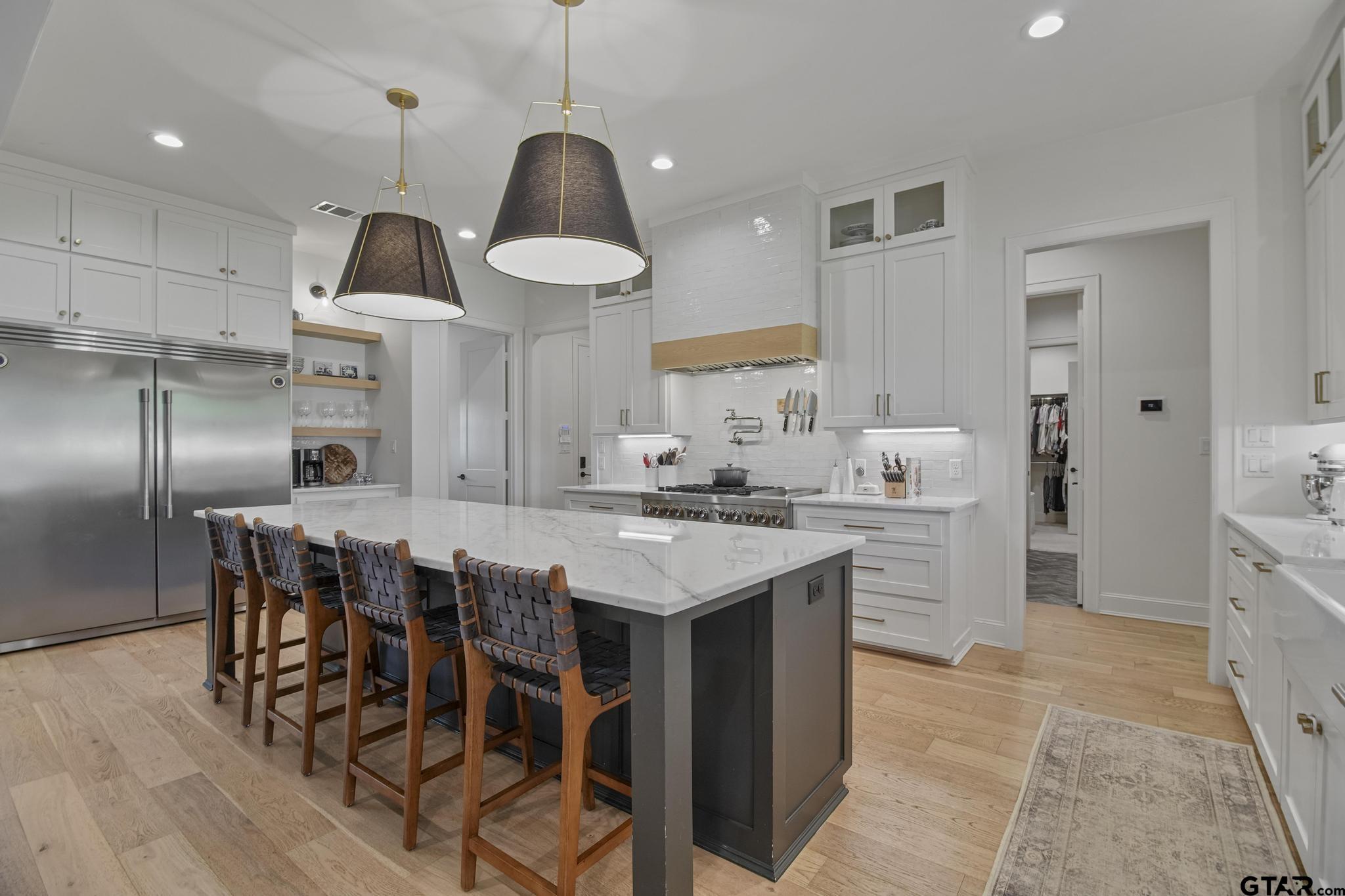 1242 Colt Lane Tyler, TX 75703 - Photo 14 of 47 a kitchen with stainless steel appliances a dining table chairs stove and refrigerator
