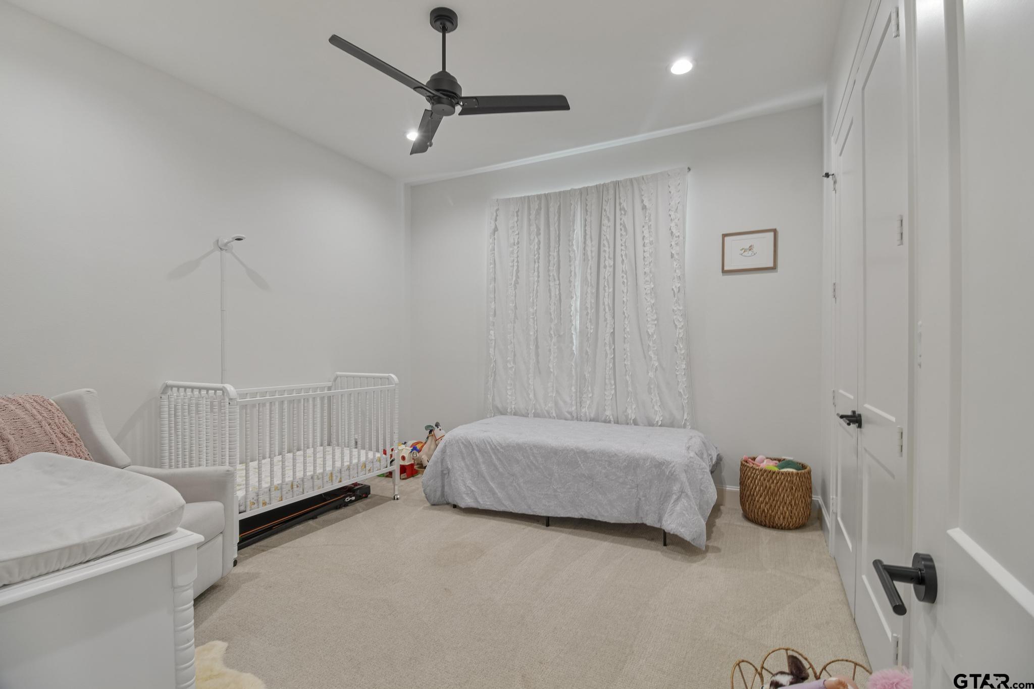 1242 Colt Lane Tyler, TX 75703 - Photo 28 of 47 a bedroom with a bed and a ceiling fan