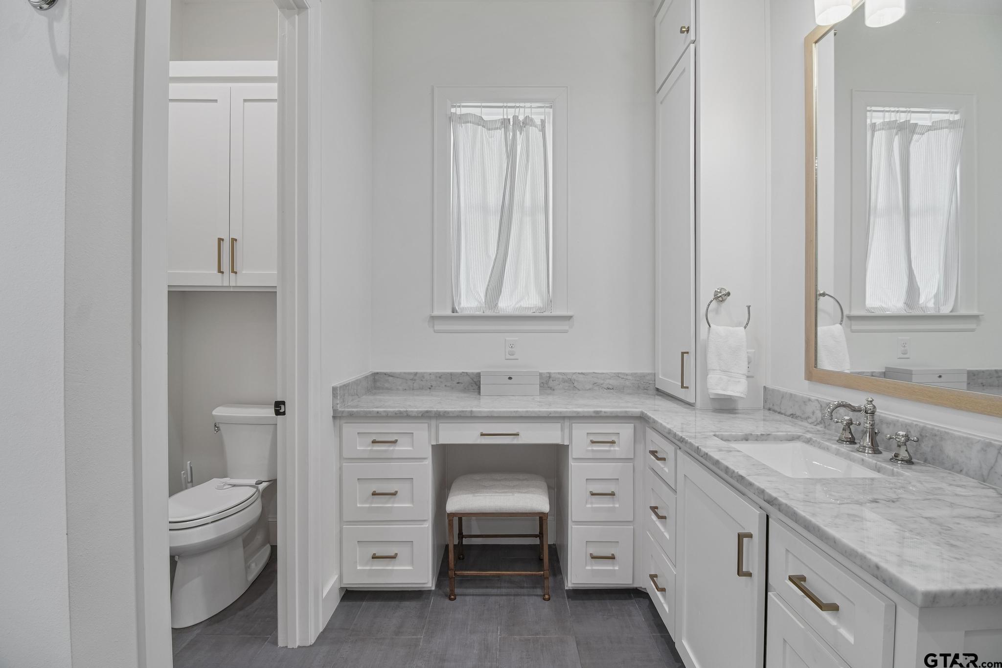1242 Colt Lane Tyler, TX 75703 - Photo 32 of 47 a bathroom with a granite countertop toilet sink and mirror