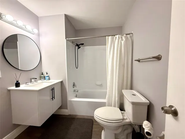 a bathroom with a sink toilet mirror and shower