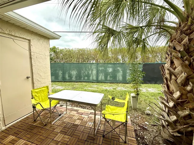 a view of swimming pool with a table and chairs under an umbrella