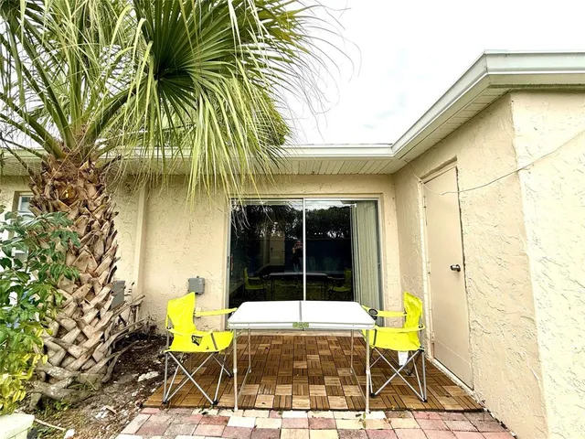 a view of a patio with table and chairs near a yard