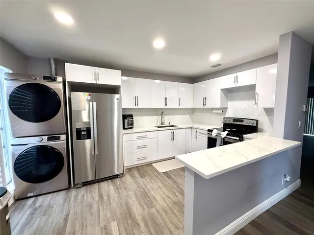 a kitchen with a stove a refrigerator and cabinets
