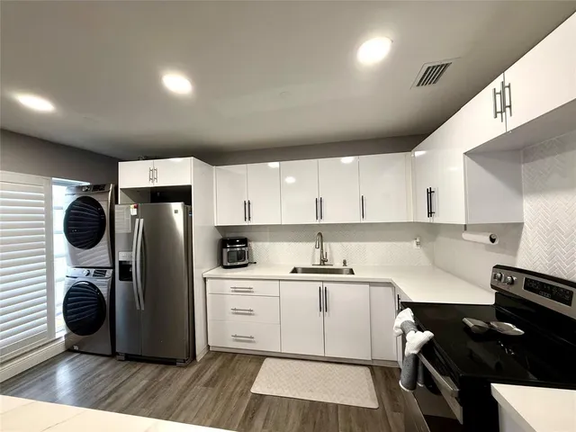 a kitchen with refrigerator cabinets and a sink
