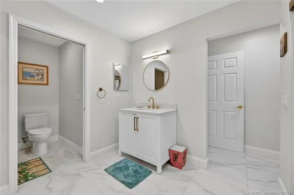 a bathroom with a toilet a sink and mirror
