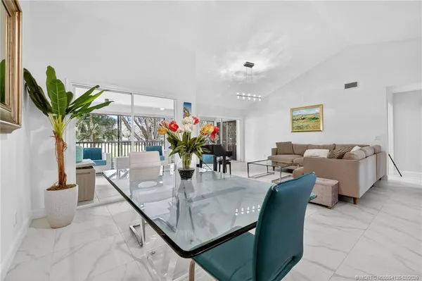 a dining room with furniture and a potted plant