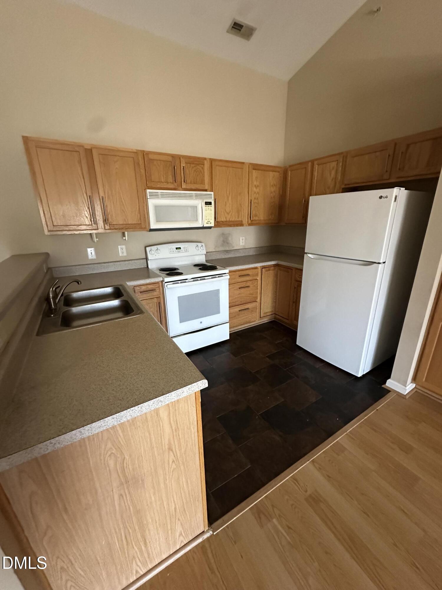 1901 Trailwood Heights Lane, Unit 302 Raleigh, NC 27603 - Photo 12 of 16 a kitchen with a refrigerator and a stove top oven