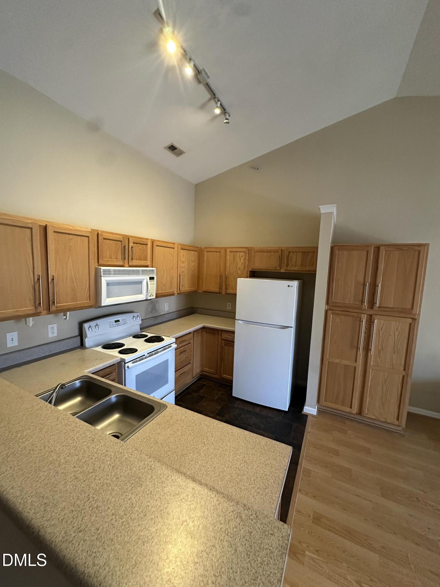 1901 Trailwood Heights Lane, Unit 302 Raleigh, NC 27603 - Photo 13 of 16 a kitchen with wooden cabinets and a sink