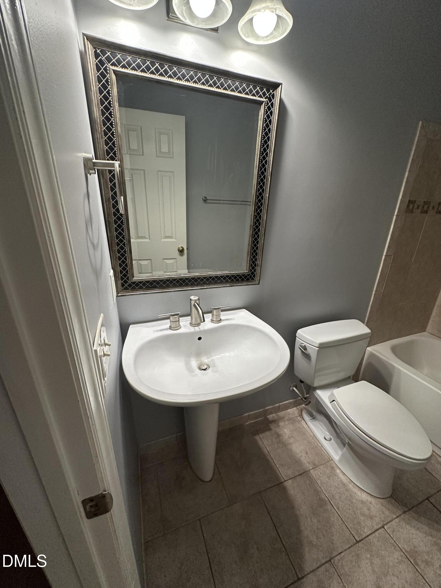 1901 Trailwood Heights Lane, Unit 302 Raleigh, NC 27603 - Photo 7 of 16 a bathroom with a toilet sink and mirror