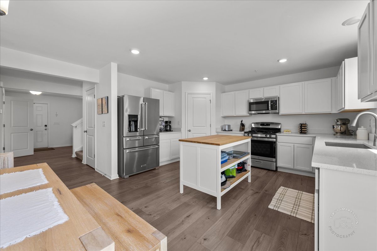 1313 Endicott Road South Elgin, IL 60177 - Photo 6 of 20 a kitchen with white cabinets and stainless steel appliances