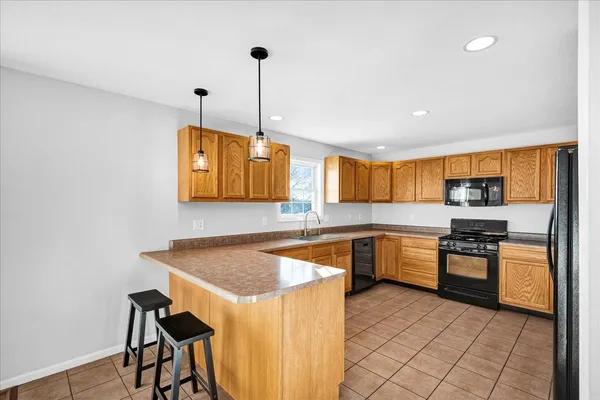 a kitchen with stainless steel appliances granite countertop a sink a stove and a wooden floors