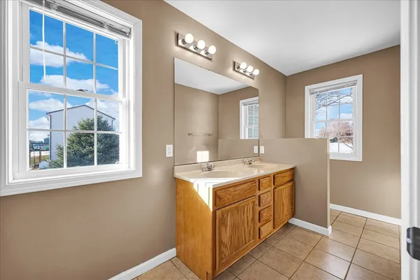 a utility room with a sink a vanity and a window