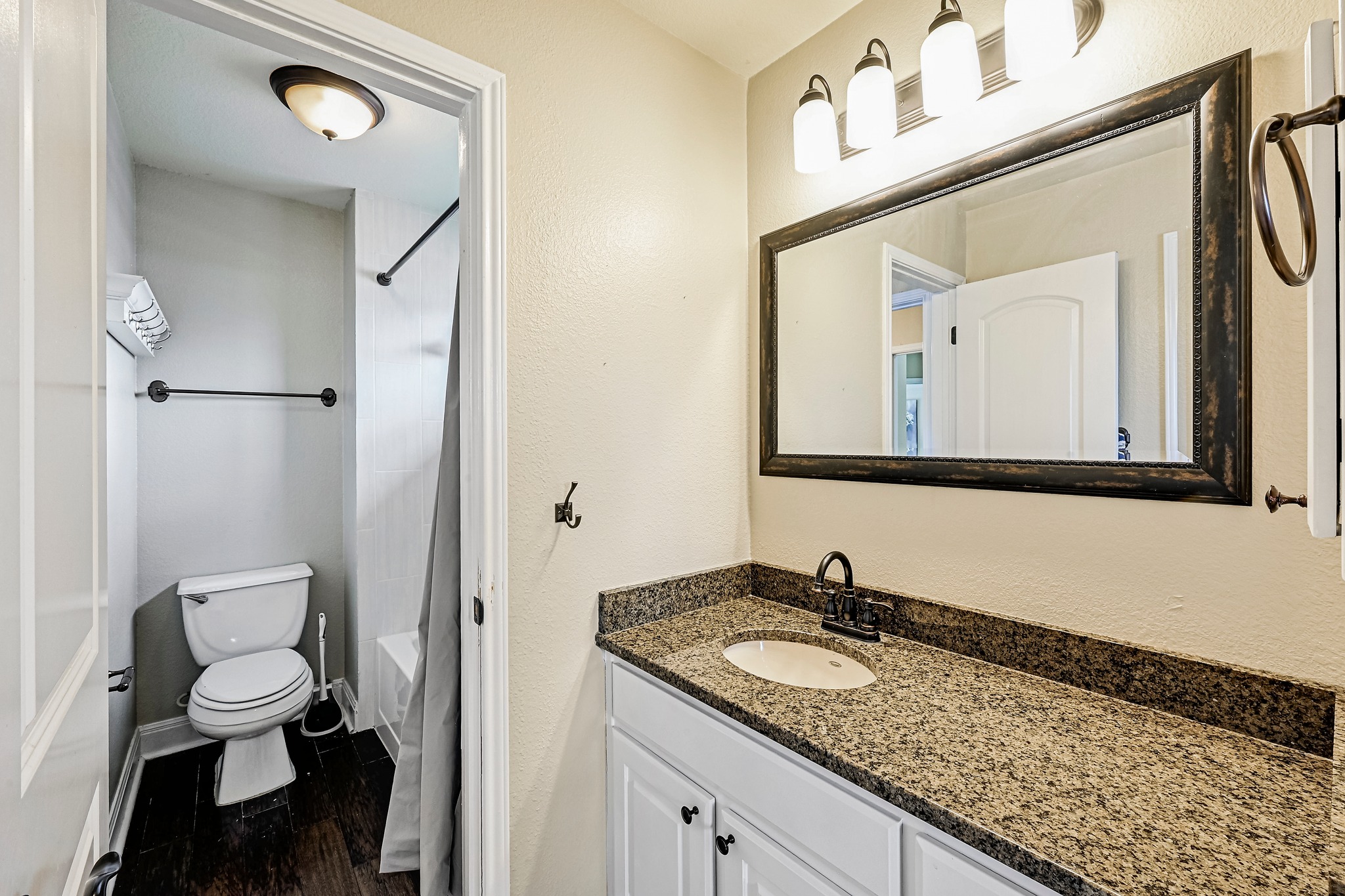 2408 Amen Corner Road Pflugerville, TX 78660 - Photo 30 of 40 Bathroom featuring a vanity with a granite-finish countertop, undermount sink, and black faucet