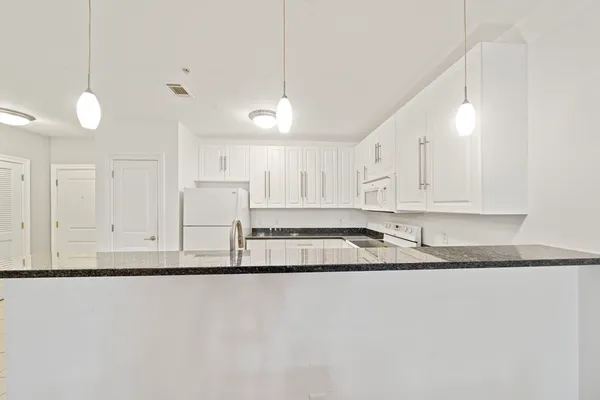 a kitchen with stainless steel appliances granite countertop a sink a stove and a refrigerator