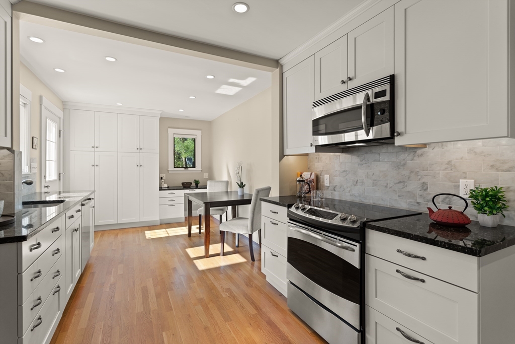 29 Kenwin Road Winchester, MA 01890 - Photo 16 of 35 a kitchen with stainless steel appliances white cabinets and a stove top oven